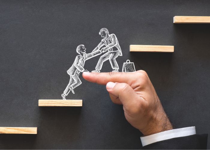 Students helping each other climb steps